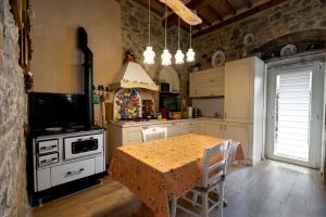a kitchen with a table and a stove top oven at La Fabbrichina in Gambassi Terme