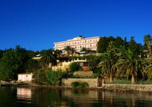 un edificio su una collina vicino a un corpo d'acqua di Aegli Hotel a Perama