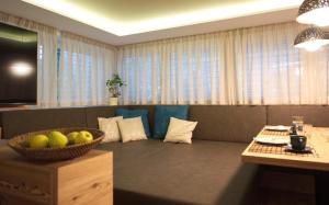 ein Wohnzimmer mit einem Sofa und einer Obstschale in der Unterkunft CityChalet family Bozen in Bozen