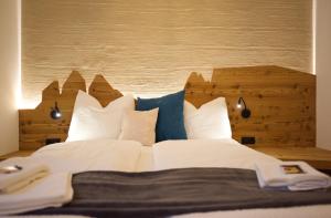 a large bed with white sheets and blue pillows at CityChalet family Bozen in Bolzano