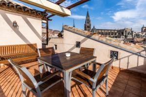 
a wooden bench sitting on top of a stone patio at Hotel Santa Isabel in Toledo
