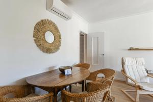 a dining room with a wooden table and chairs at Appartement Provenza - Welkeys in Saint-Cyr-sur-Mer