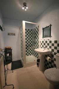 ein Bad mit einer Dusche und einem Waschbecken in der Unterkunft Le Relais des Capucines in Largnac