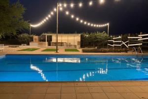 una piscina por la noche con luces sobre ella en Casa Rural VILLA KAIROS, en Ajofrín