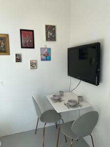 a white table with two chairs and a tv on a wall at Bed & Beach Amsterdam in Amsterdam +10 photos