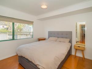 ein Schlafzimmer mit einem großen Bett und einem Fenster in der Unterkunft Idyll Thyme - Hahei Holiday Home in Hahei
