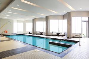 a large swimming pool with chairs in a building at Grey Eagle Resort in Calgary