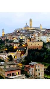 un gruppo di edifici in una città di notte di La Finestra su Siena a Siena