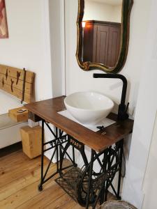a sink on a wooden table with a mirror at Unser Keltenhof in Niederstetten