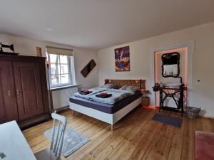 - une chambre avec un lit et du parquet dans l'établissement Unser Keltenhof, à Niederstetten