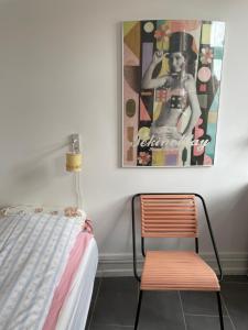 a bedroom with a bed and a chair and a painting at Sundbyvestervarehus in Copenhagen