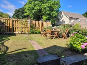 a backyard with a table and chairs and a fence at Seahouses cottage in Seahouses