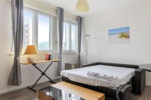 een kamer met een bed, een tafel en ramen bij Charming studio 15 min from Lille in Marcq-en-Baroeul - Welkeys in Marcq-en-Baroeul