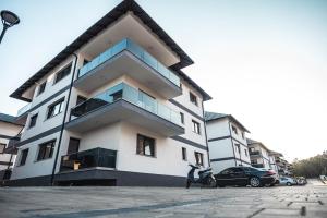 a building with a car parked in front of it at La Stejari Apartment in Suceava