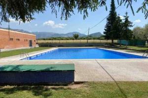 a large blue swimming pool next to a building at Ca l’Albert - Casa rural acollidora in Isona
