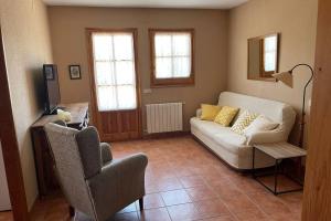 a living room with a couch and a chair at Ca l’Albert - Casa rural acollidora in Isona