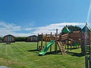 a playground with a slide in the grass at Greencraig Pods in Buckie