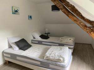 2 Betten in einem Zimmer mit einer Treppe in der Unterkunft Les gîtes du château du cèdre in Manneville-ès-Plains