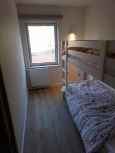 a bedroom with a bunk bed and a window at Hakuuna Matata Appartement Koksijde met staanplaats in Koksijde