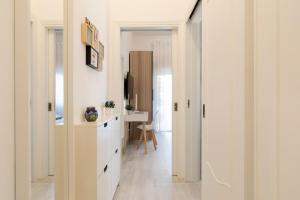 a hallway with white cabinets and a desk at Nuovo Appartamento sulla spiaggia con larga terrazza di 70 mq e posto auto privato in Anzio +31 photos