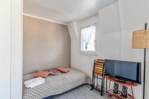 Habitación pequeña con cama y TV. en Nice flat with balcony - Trouville - Welkeys, en Trouville-sur-Mer