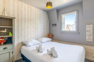 1 dormitorio con cama blanca y ventana en Nice flat with balcony - Trouville - Welkeys, en Trouville-sur-Mer
