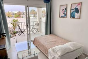 sypialnia z łóżkiem i balkonem ze stołem w obiekcie Oasis View Lanzarote w Costa Teguise