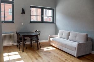 salon z kanapą i stołem w obiekcie Apartamenty Nowy Browar Gdański w Gdańsku