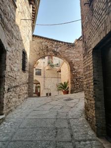 an alley in an old stone building with an archway at Gabri's Home in Spello
