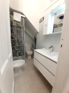a bathroom with a sink and a toilet and a shower at Casa Orchidea in Taormina