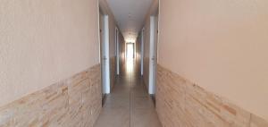 um corredor com um longo corredor com paredes brancas em Paleo Inn Hotel em Paleokastritsa