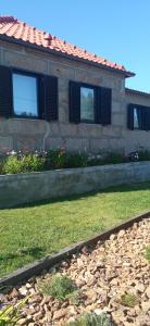 a house with two windows and a grass yard at Casa dos Matos in Ponte de Lima