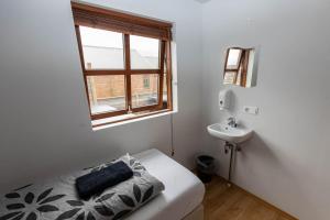 a bedroom with a bed and a sink and a window at Lysuholl in Snæfellsbær