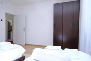 um quarto com três camas e um armário castanho em Urban Apartment Visoko em Visoko