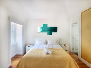 een slaapkamer met een groot bed en een gele deken bij Casa Conceição by LovelyStay in Funchal