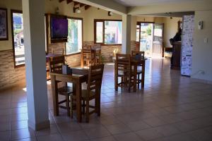 a dining room with tables and chairs and a television at El Alamo in El Chalten