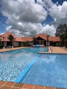 a large swimming pool in front of a house at Hotel Campestre Los Chiguiros in Villavicencio