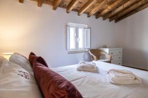 um quarto com uma cama com lençóis brancos e uma janela em Casa da Judiaria em Castelo de Vide