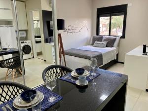 a room with a bed and a table and chairs at Studio32B decorado Bairro Fragata in Marília