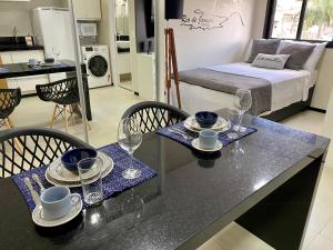 a kitchen with a table with plates and glasses on it at Studio32B decorado Bairro Fragata in Marília +27 photos