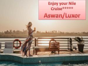 a woman is standing next to a swimming pool at Luxor Luxury Nile Cruises - From Luxor 04 & 07 Nights Each Saturday - From Aswan 03 & 07 Nights Each Wednesday in Luxor