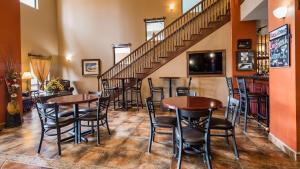 eine Bar mit Tischen und Stühlen in einem Zimmer mit Treppen in der Unterkunft Best Western Plus Country Inn & Suites in Dodge City
