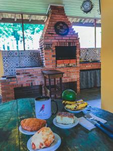 a table with several different types of cakes on plates at Pescaria em Iguape - Belo Rancho Subauma in Iguape