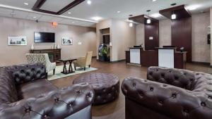 a waiting room with leather couches and a bar at Best Western Plus Lee's Summit Hotel & Suites in Lees Summit