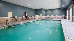 a large swimming pool with chairs and a table at Best Western Plus Lee's Summit Hotel & Suites in Lees Summit