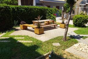 a wooden picnic table sitting on a brick patio at Μονοκατοικία με κήπο στη θάλασσα. in Korinthos