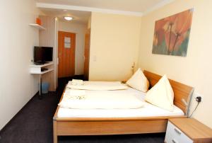 a hotel room with two beds and a television at Pension Tennisweber in Schwechat