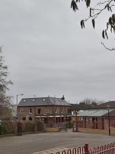 a park with a bench in front of a building at Eagle Hotel Luton Airport in Luton