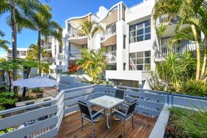 un patio con mesa y sillas frente a un edificio en Portobello Resort Apartments, en Gold Coast