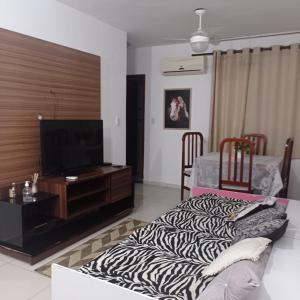 カンポス・ドス・ゴイタカゼスにあるCampos Rede Apto Xのテレビとシマウマ柄のソファのあるリビングルーム